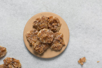 Overhead view of nigerian coconut candy on a countertop, top view of candied coconuts discs, flatlay of bukayo candy or coconut drops
