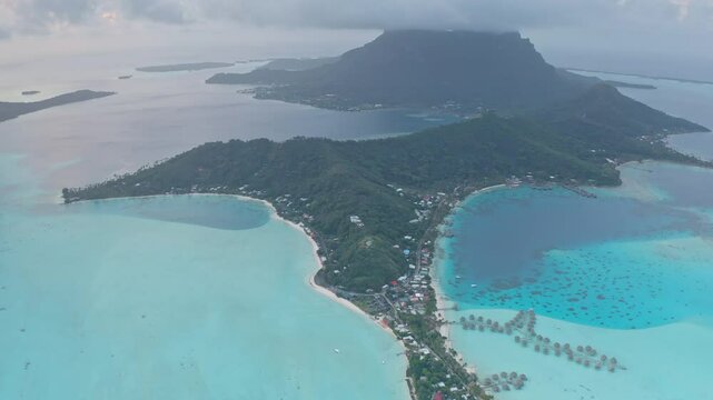 Stunning aerial view of Bora Bora island, lush vegetation, and the surrounding turquoise lagoon, creating a breathtaking tropical paradise in French Polynesia. Popular travel destination background