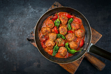 Traditional slow cooked American Tex Mex meatballs with mincemeat, paprika and tomatoes served in a spicy sauce as close-up in a rustic skillet