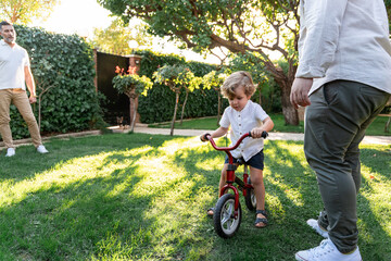 Loving gay couple supports son learning to ride bicycle