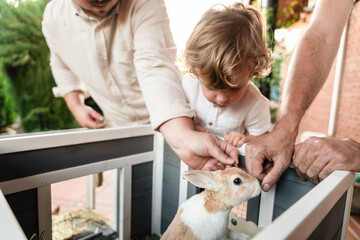Family bonding: gay couple and son with pet rabbit