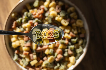 Celebrating New Year 2026 with number shaped pasta on a spoon