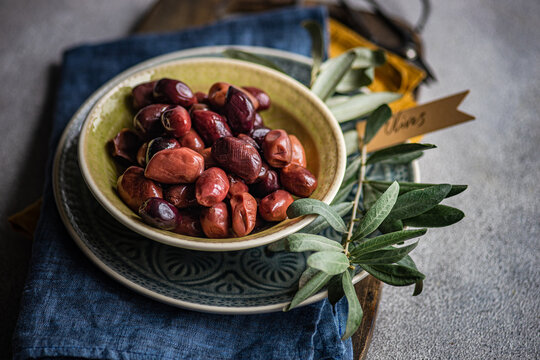 Greek BBQ olives in a bowl and olive branches