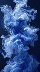 Fototapeta premium A swirling formation of blue smoke against a dark background, creating an ethereal effect.