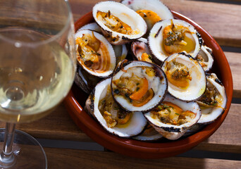 Dish of Mediterranean cuisine - tasty baked Dog cockles (bivalve mollusks) served in bowl