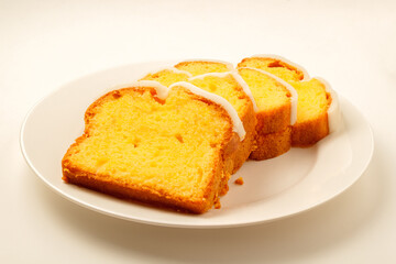 Iced lemon cake loaf slices on white plate