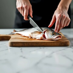 Obraz premium Cutting Fish with Knife on Cutting Board: A Simple Step in Culinary Preparation
