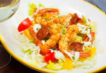 Salad with fried tiger shrimps, chorizo sausages and fresh cabbage, pepper, tomatoes