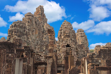 Ancient temple Bayon Angkor complex with stone faces of Buddha in Siem Reap on blue sky cloudy...