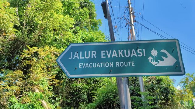 Street view of Jalur Evakuasi Evacuation Route sign on tropical island of Pulau Weh in Aceh Province of Indonesia