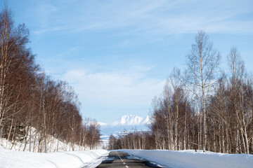 雪が溶け始めた道路と雪山　十勝岳連峰
