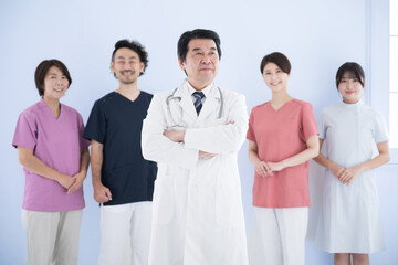 Image of multiple (5) side-by-side healthcare professionals Doctor and nurse, physical therapist team Standing Looking up Thinking Doctor light blue background