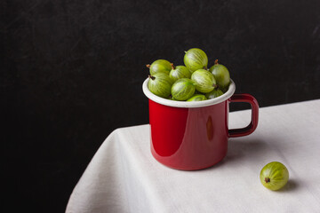 Fresh green gooseberry berries on a light background