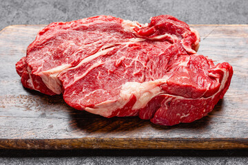 Raw beef meat on a wooden cutting board