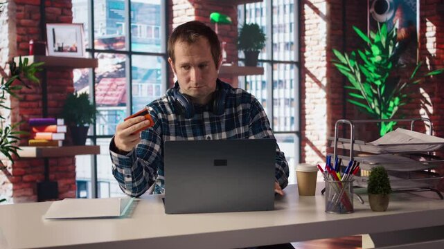 Man doing internet shopping, carefully typing credit card information on laptop in apartment. Shopper adding payment method on website while at home in living room, camera A