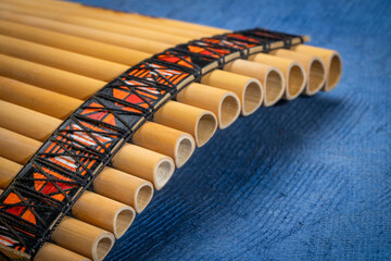bamboo pan flute instrument from Peru against textured art paper © MarekPhotoDesign.com