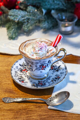 Peppermint hot chocolate with whipped cream and a peppermint stick