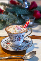 Peppermint hot chocolate with whipped cream and a peppermint stick