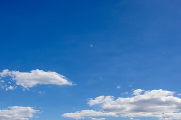 clear blue sky with a few clouds. The sky is very bright and the clouds are scattered throughout