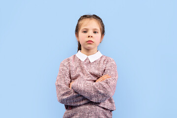 A girl stands confidently with her arms crossed, displaying a cheerful expression. Her happy...