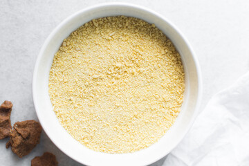 Overhead view of Yellow garri in a white bowl, top view of nigerian garri in a ceramic bowl, fried cassava, garri for eba