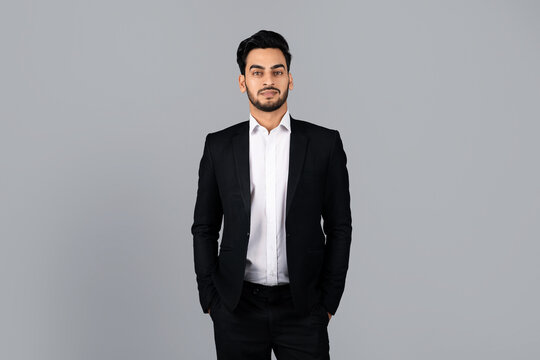 A young Middle Eastern businessman stands confidently in a studio setting. His formal attire and demeanor reflect his entrepreneurial spirit and professionalism in a corporate environment.