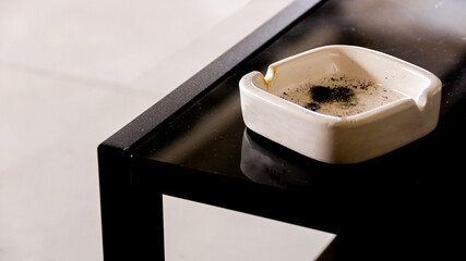 top view of metal ashtray on rattan woven table