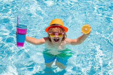 Kid boy swimming in pool play with floating ring. Smiling cute kid in sunglasses swim with inflatable rings in pool in summer day.