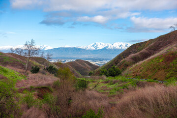 View over Chino Hills / Inland Empire in California with snowy mountains in the background. Visible are Ontario Peak, Mount Baldy and other San Bernardino mountains. 