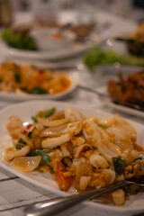 Stir fried squid with salted egg yolk on dish at restaurant