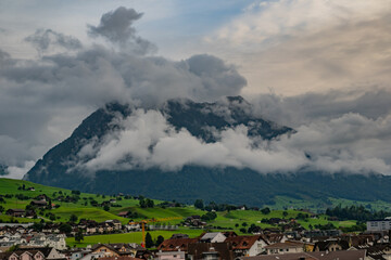 Fototapeta premium Mountain in the Alps in summer, panoramic view with mountain. Switzerland Alps nature and travel. Alpine scenery. Mountain with lake in Alps. Summer view over the lake and the alps in Switzerland.