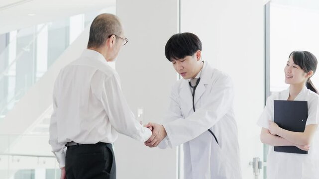 握手をする患者と医師