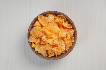 Spicy cassava chip chili sauce in a wooden bowl photographed with studio light with a wooden theme