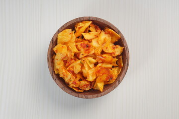 Spicy cassava chip chili sauce in a wooden bowl photographed with studio light with a wooden theme