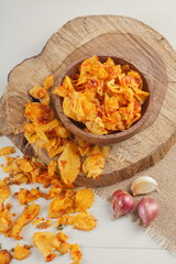 Spicy cassava chip chili sauce in a wooden bowl photographed with studio light with a wooden theme