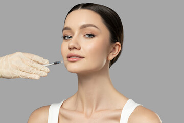 Botox. Skin Care. A girl gets a botox injection, on a light background.