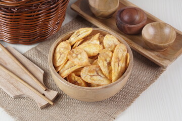 Indonesian banana chips on a wooden bowl with a traditional property theme photographed with studio light