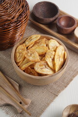 Indonesian banana chips on a wooden bowl with a traditional property theme photographed with studio light