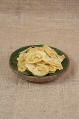 Indonesian banana chips on a wooden bowl with a traditional property theme photographed with studio light