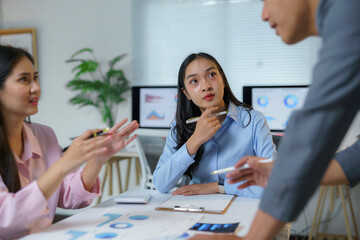 Fototapeta premium Businesswomen engaging in a productive discussion, analyzing charts and data during an office meeting, fostering collaboration and strategic decision making