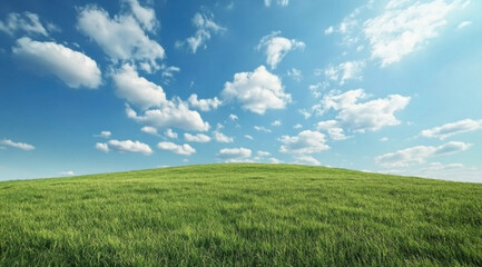Fototapeta premium vibrant green hill under bright blue sky filled with fluffy clouds creates serene landscape. This picturesque scene evokes sense of tranquility and natural beauty