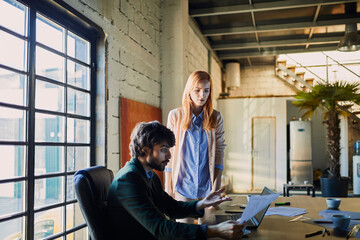 Colleagues reviewing documents in modern industrial office setting