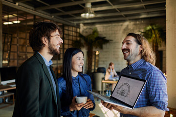 Colleagues discussing architectural project on laptop in modern office