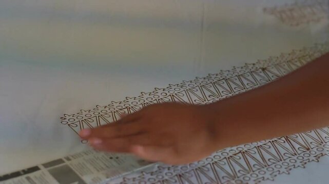 Footage. Close up of the batik stamping process. Making batik cloth by stamping