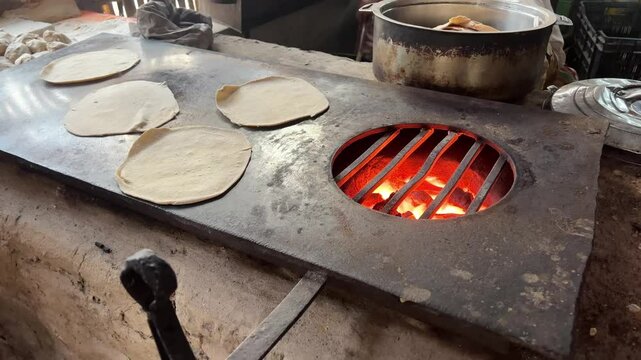 Fresh rotis in making on hot stove.