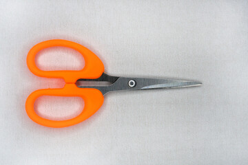 Small scissors with curved and pointed tips on a white background. orange scrapbooking scissors with Stainless Steel blades. Small bent embroidery thread scissors for handicrafts.