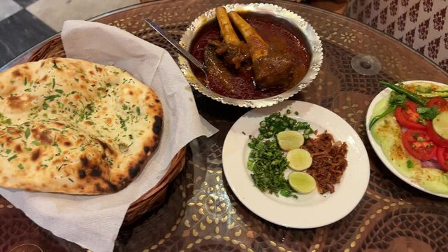 Assortment of delicious naan with mutton nalli nihari at a restaurant in India.
