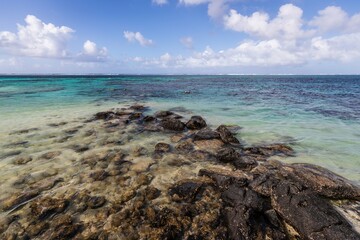Rocky Shoreline with Clear Turquoise Waters and Blue Sky, Mauritius