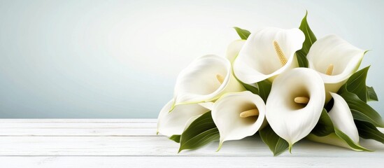Close-up white calla lilies bouquet on wooden surface, delicate arrangement with pristine petals, vibrant green leaves, peaceful ambiance
