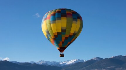 Obraz premium Colorful Hot Air Balloon Soaring Over Snowy Mountains